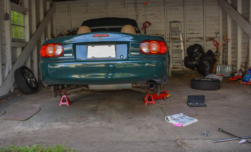 Up on the jack stands. Note the well-used shop manual. Purple post-its denote the pages describing brake pad changes and changing the rear differential oil.